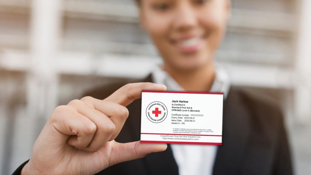 A person in a suit holds up a Red Cross certification card. The card includes details such as the name "Jack Harlow," certification number, start and end dates, and a CPR/AED for Professional Rescuers and First Aid credential.