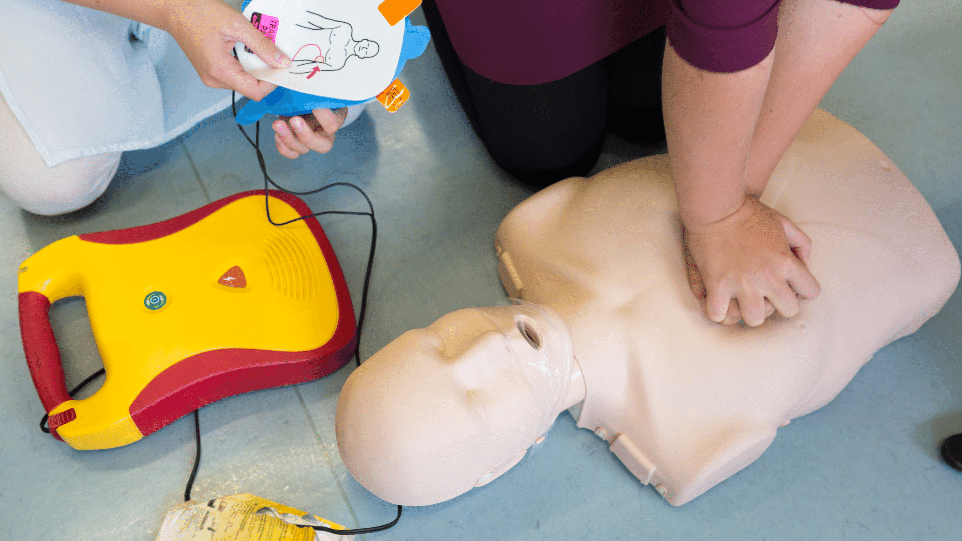 Person using AED on an adult dummy.