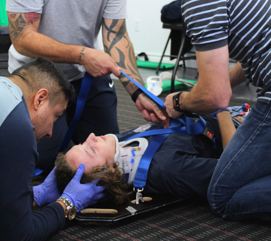 Spinal stabilization on a backboard practised in an EMR course