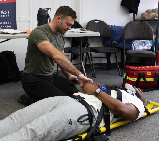 Taking vital signs on a backboarded patient in a First Responder class