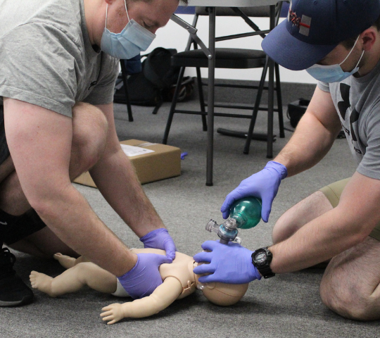 Instructor demonstrating infant bag-valve-mask technique during a BLS class in Scarborough