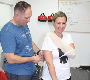 Applying a triangular bandage sling during first aid training