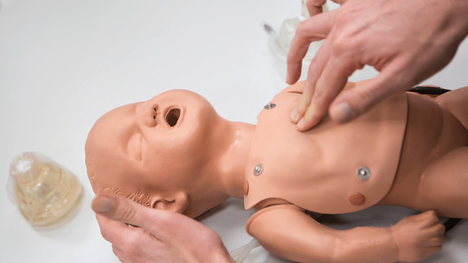 Performing CPR on a baby dummy.
