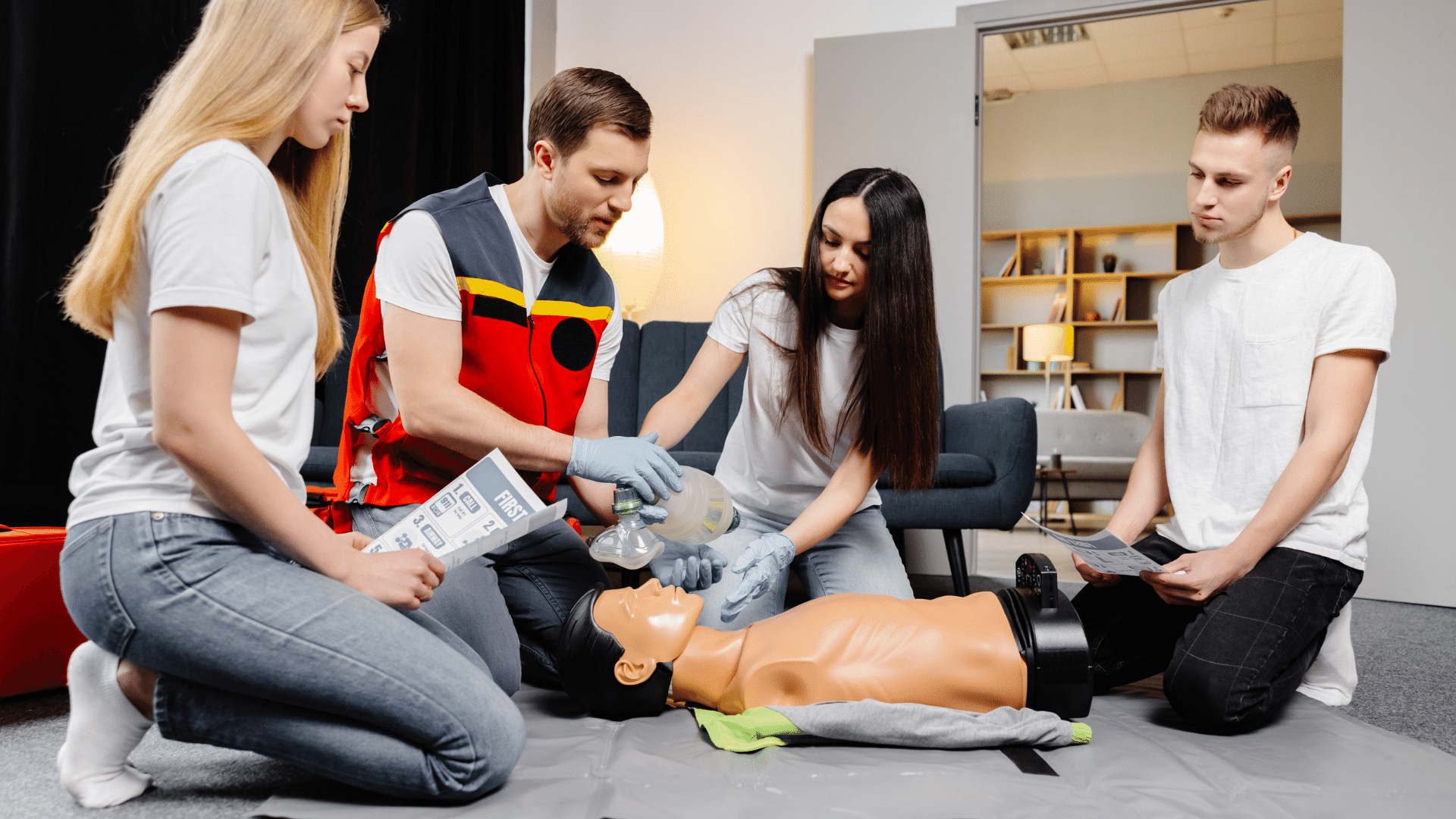 Group of people learning how to perform CPR on a dummy.