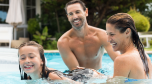 Parents giving swimming lessons to their child.