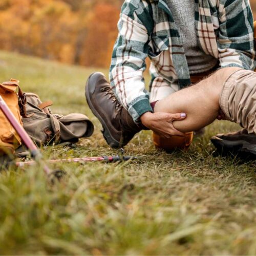 A person experienced in first aid for travellers helping someone.