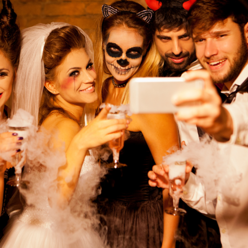 People taking a group picture using a phone in their halloween costumes.