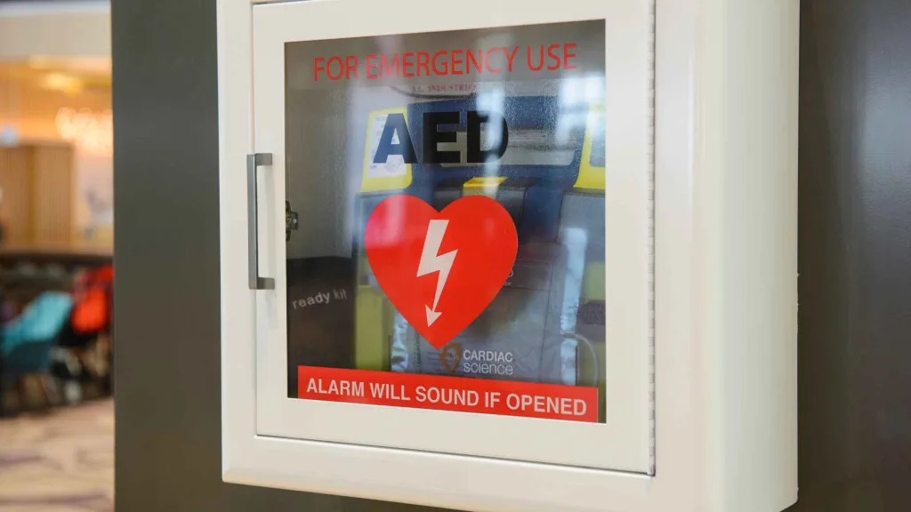 an aed in a metal and glass case attached to the wall in a public space