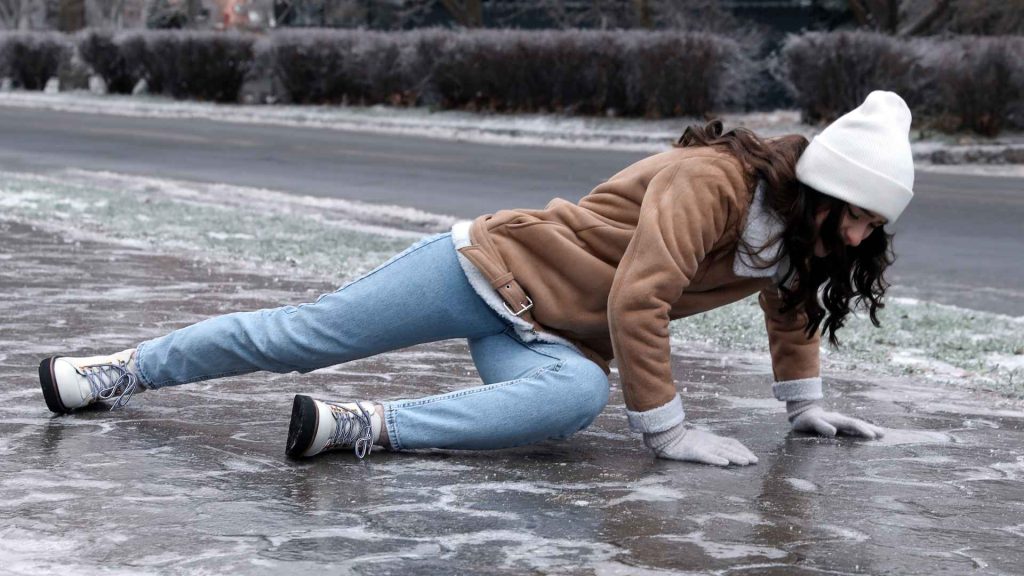woman who has fallen on ice in the winter time