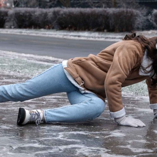woman who has fallen on ice in the winter time