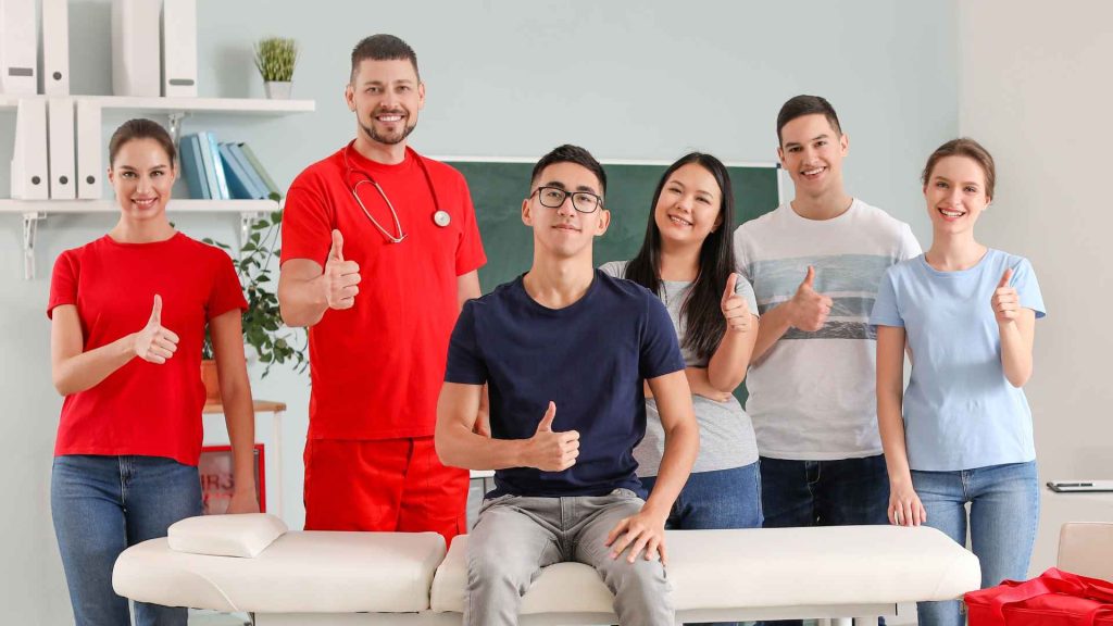 students and first aid teachers smiling and giving a thumbs up towards the camera after a training class