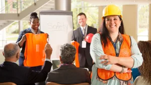 Workers in orange safety vests and hard hats attending a JHSC certification training session in a workplace safety classroom in Canada
